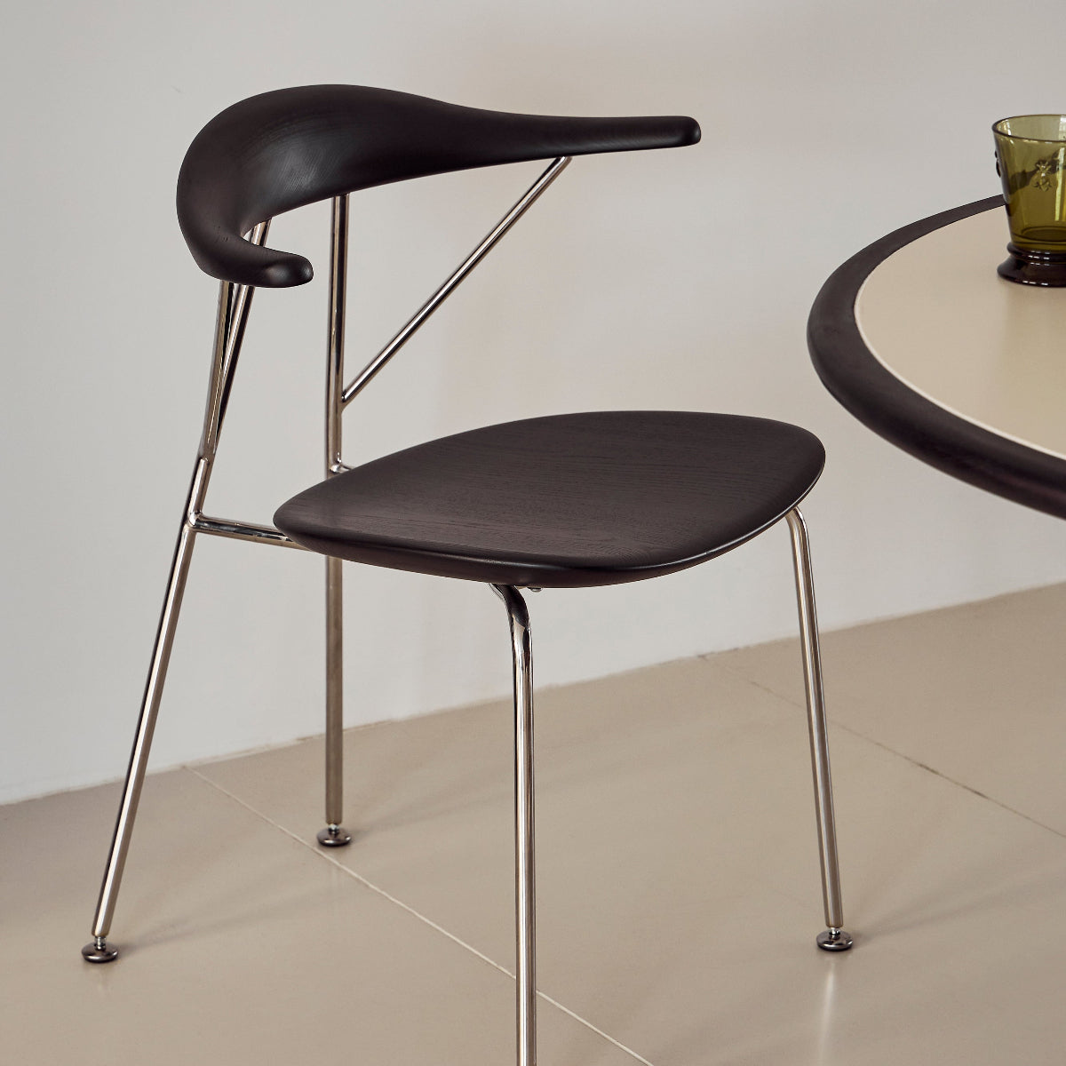 Modern black chair with metal legs on a neutral background