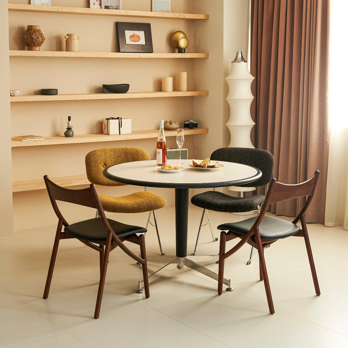 Modern dining area with a round table and four chairs in a well-lit room.