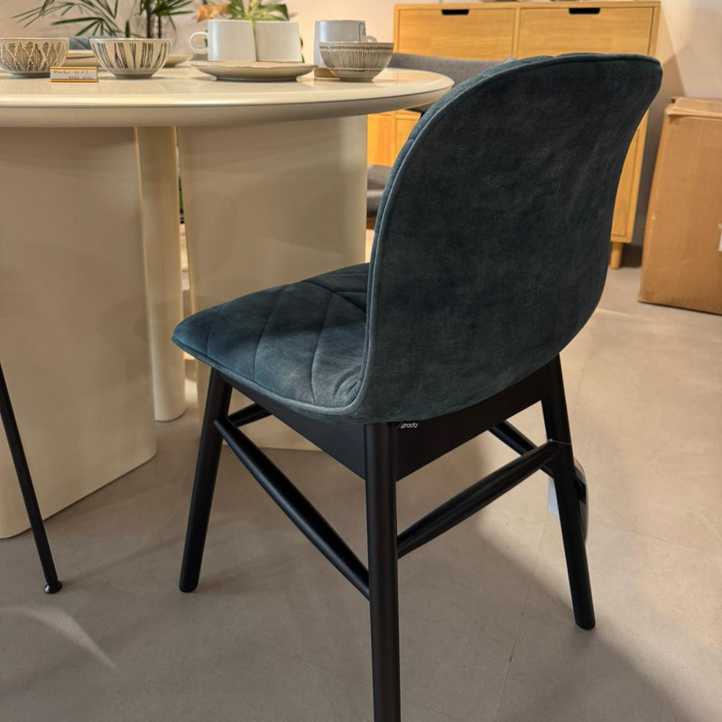 Blue chair in a dining room setting with a table and decor.