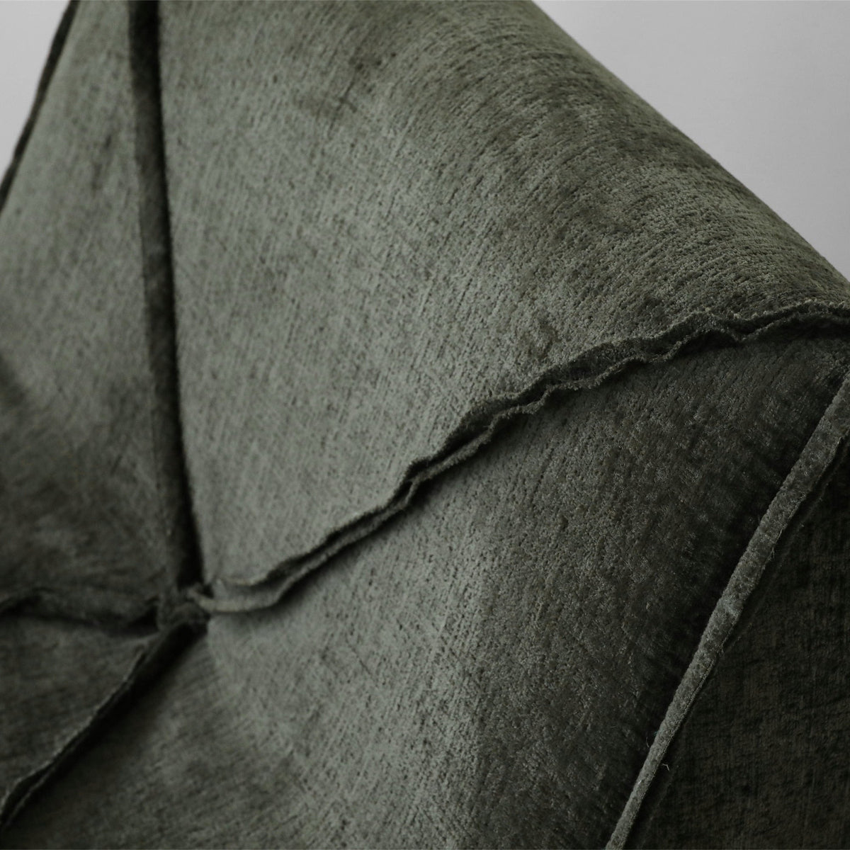 Close-up of a dark green fabric texture on a wooden surface