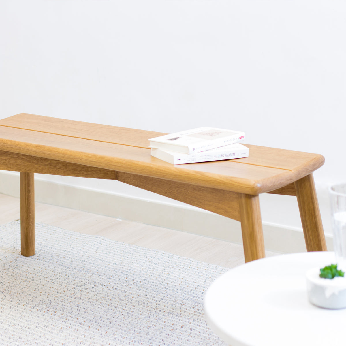 Wooden coffee table with books on a light gray rug
