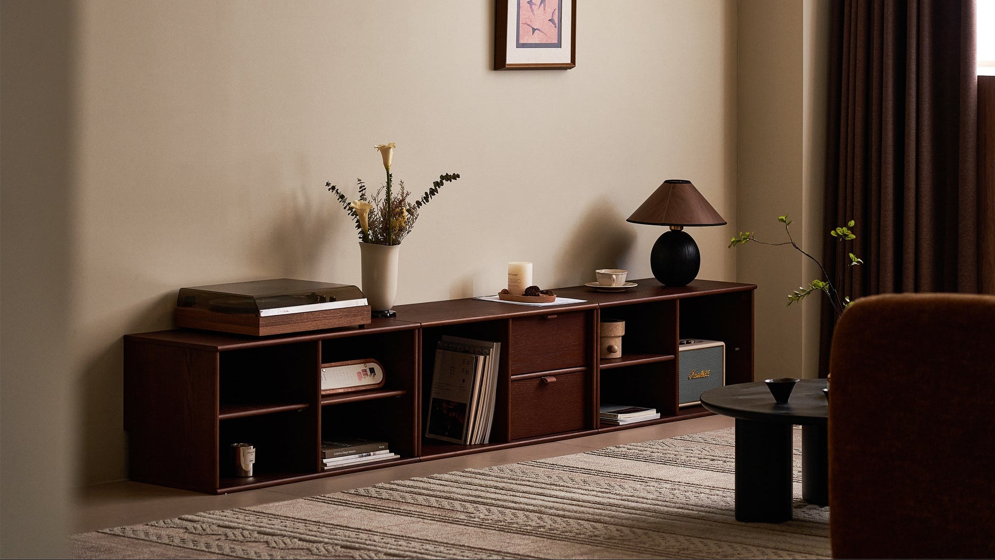 Living room with a wooden entertainment console, books, and decorative items.