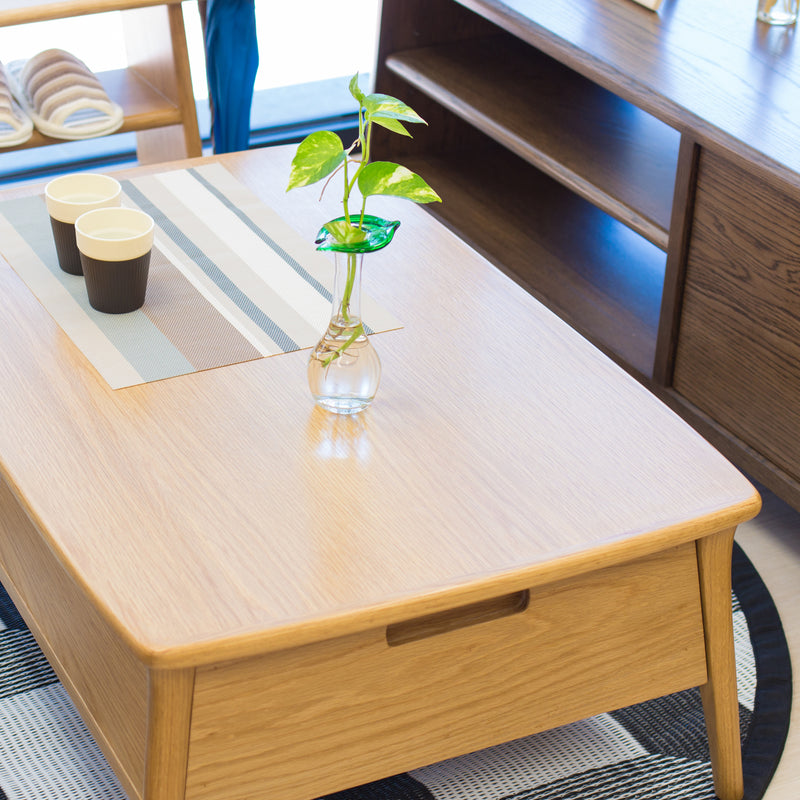 Wooden coffee table with a vase of green leaves in a room setting